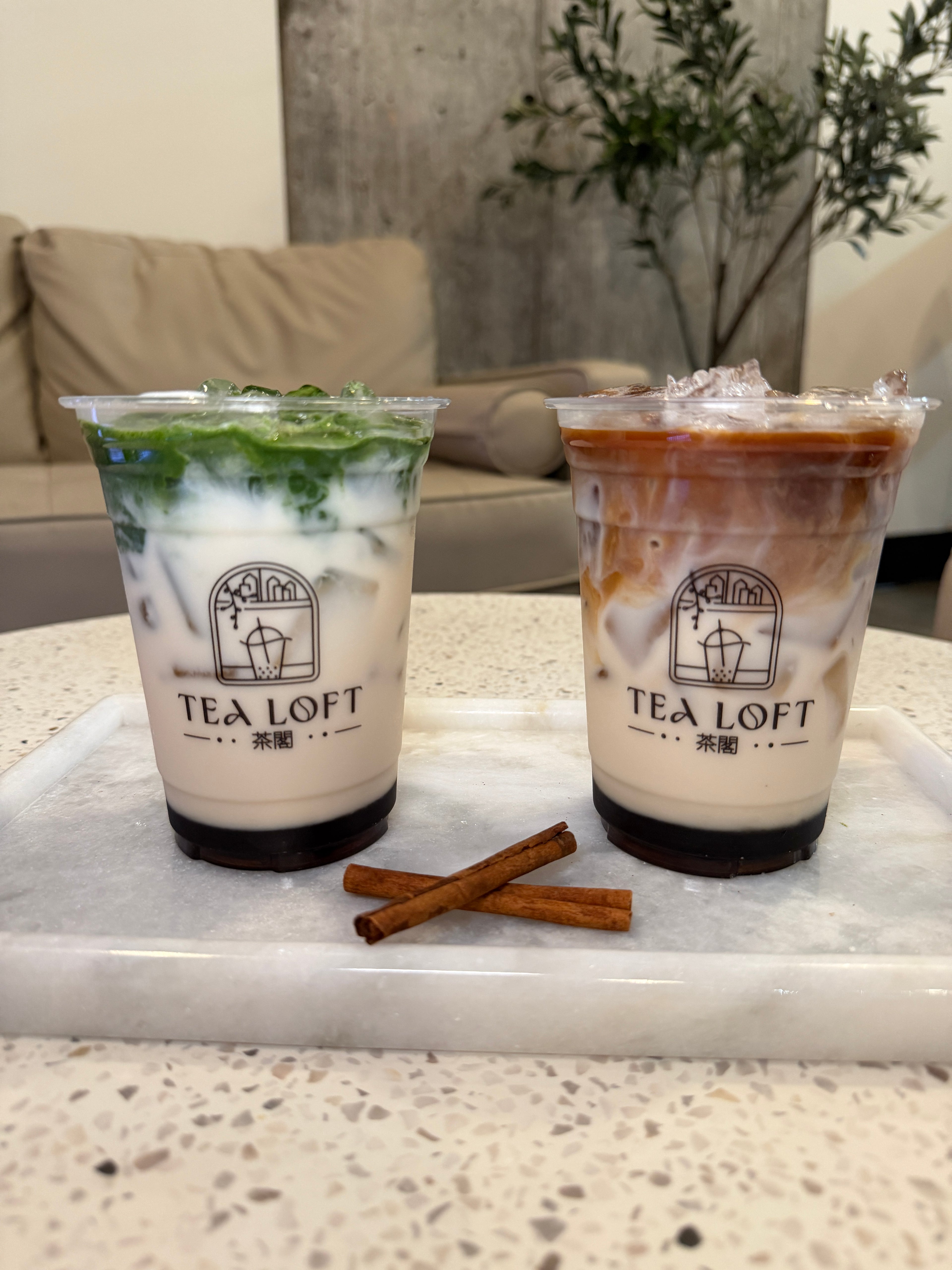 Two iced drinks from Tea Loft on a stone surface with cinnamon sticks. Best Matcha in portland oregon on Mississippi ave 